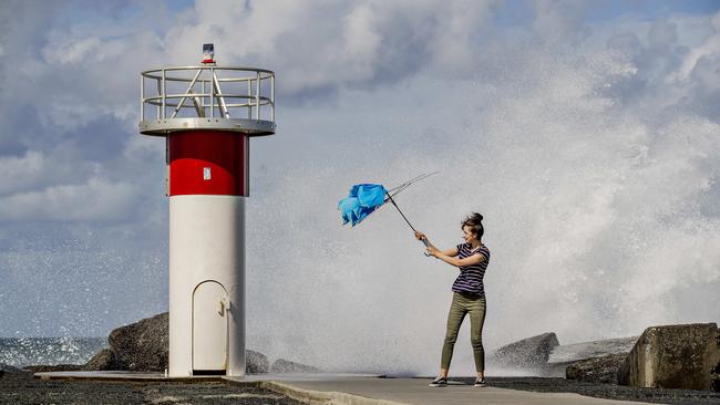 Tarsha Talebi struggling with her umbrella in the strong winds at the Spit. Picture: Jerad Williams