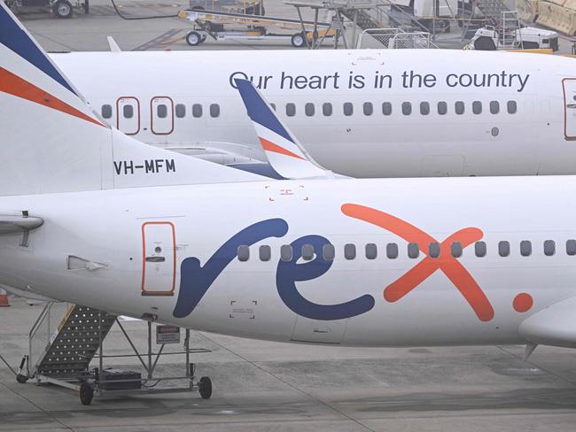 Rex Airlines Boeing 737 planes lay idle on the tarmac at Melbourne's Tullamarine Airport on July 31, 2024. The Australian regional airline Rex cancelled flights as it entered voluntary administration on July 31, leaving the fate of the country's third-largest carrier in serious doubt. (Photo by William WEST / AFP)