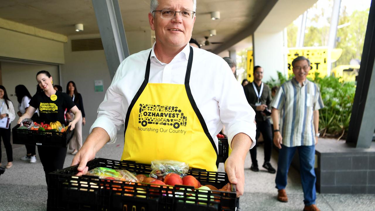 Scott Morrison carries a box of fruit and vegetables to be donated by the charity Ozharvest. Picture: NCA NewsWire / Dan Peled