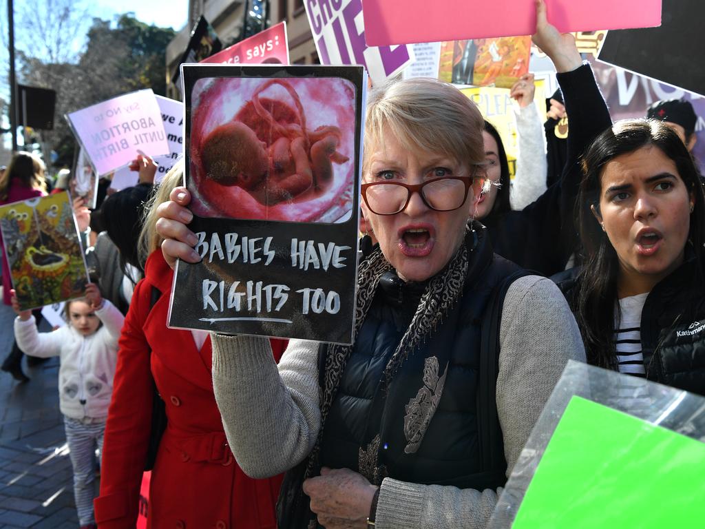 Anti-abortion advocates hold placards during a rally outside the New South Wales Parliament house in Sydney, Tuesday, August 6, 2019. (AAP Image/Joel Carrett)