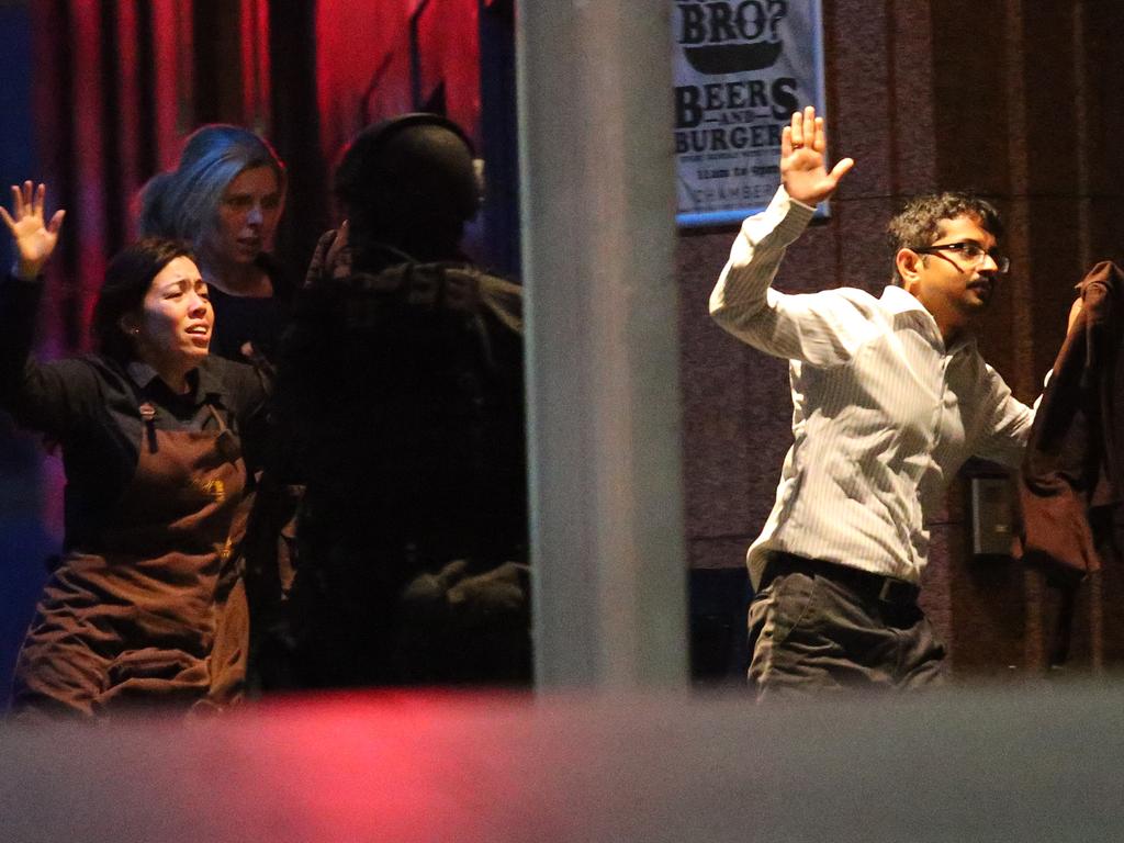 Hostages run to safety during a cafe siege in the central business district of Sydney. Picture: Rob Griffith (AP)