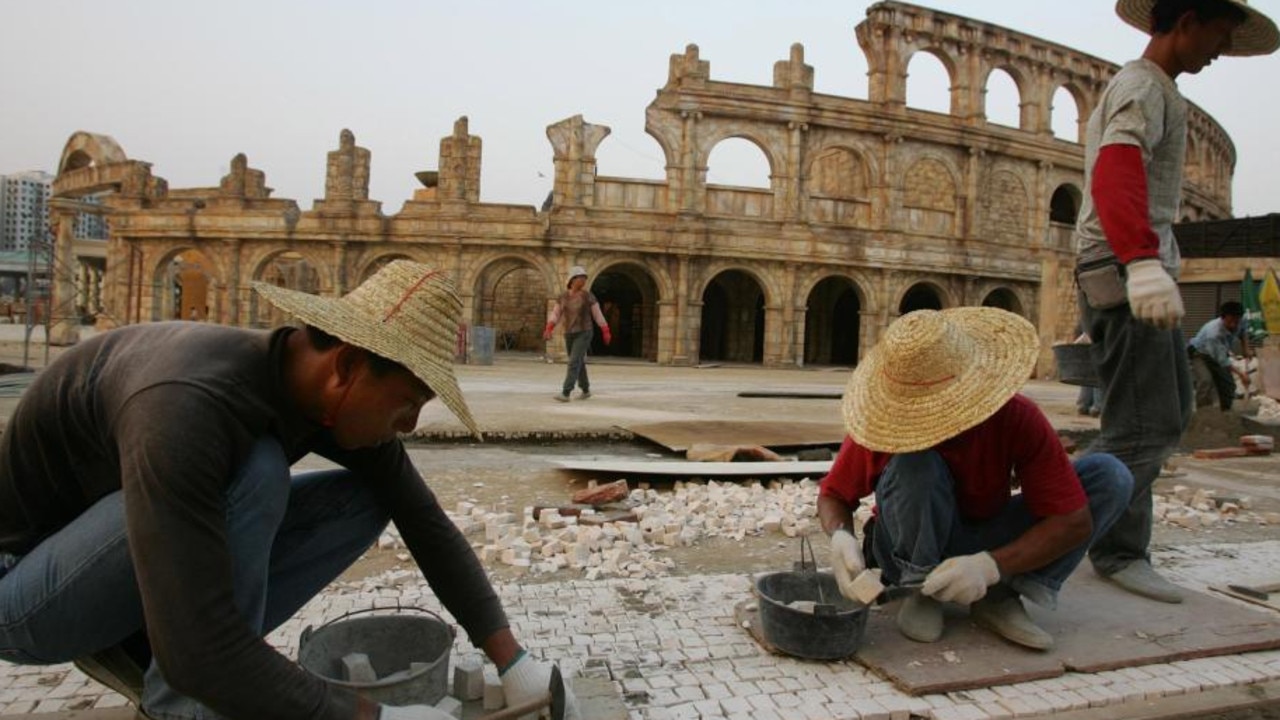Workers build a pavement outside a replica of the Roman Colosseum in Macau.