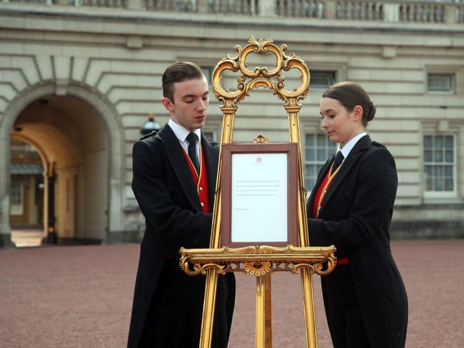  Footmen Stephen Kelly and Sarah Thompson set up the official notice on an easel at the gates of Buckingham Palace. Picture: AFP