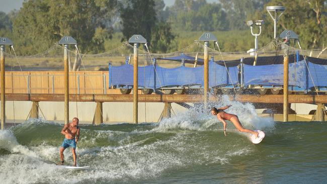 Surfers Kelly Slater and Stephanie Gilmore surf a wave at Slater’s Surf Ranch in California, which uses similar technology to produce man-made waves. Photo: Charley Gallay/Getty Images for Breitling.