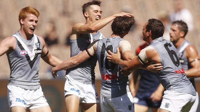 Connor Rozee gives rookie teammate Zak Butters a pat on the head after the small forward kicked his first AFL goal against Melbourne at the MCG on Saturday. Picture: Daniel Pockett (AAP)