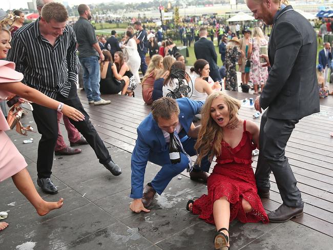 MELBOURNE, AUSTRALIA - NOVEMBER 06: Racegoers stumble as they make their way home following Melbourne Cup Day at Flemington Racecourse on November 6, 2018 in Melbourne, Australia. (Photo by Scott Barbour/Getty Images)