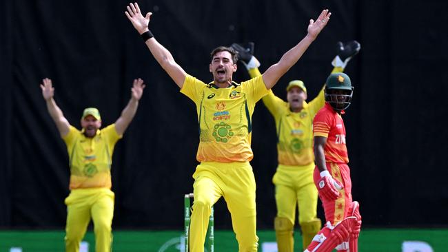 Australia's Mitchell Starc (C) appeals successfully for an LBW decision against Zimbabwe batsman Wessly Madhevere (R) during the second one-day international (ODI) cricket match between Australia and Zimbabwe at the Riverway Stadium in Townsville on August 31, 2022. (Photo by William WEST / AFP)