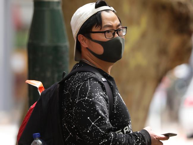 A tourists at Potts Point as part of a tour keeps his mask on after being dropped off. Picture: Matrix