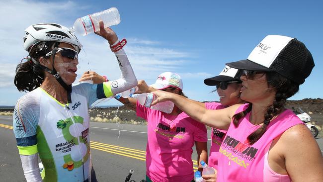 Turia Pitt gets water poured over her by aid station volunteers to help keep her cool during the bike leg . Pic: Michael Klein