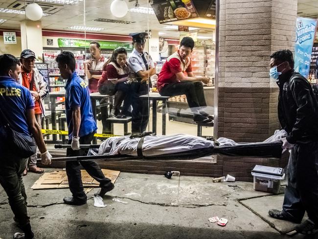 Funeral parlour workers carry away Edwin Mendoza Alon-Alon, 36, who was shot in the head outside a 7-Eleven store, in the Paranaque area of Manila. Picture: Daniel Berehulak/The New York Times/Redux/Headpress