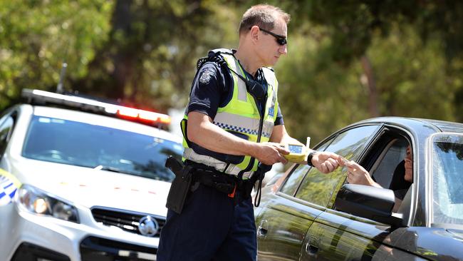 Nunawading highway patrol Leading Senior Constable Tibor Hernyak breath-tests a motorist. Picture: Steve Tanner