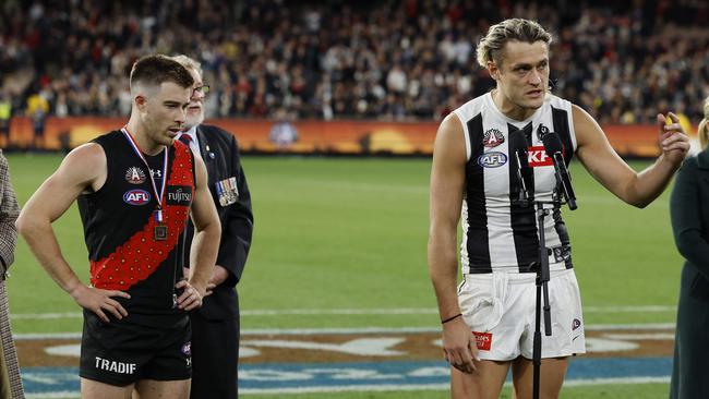 MELBOURNE , AUSTRALIA. April 25, 2024.  AFL.. Anzac Day.  Essendon vs Collingwood at the the MCG. Darcy Moore of the Magpies and Zach Merrett of the Bombers make a joint speech after the match was a draw    . Pic: Michael Klein