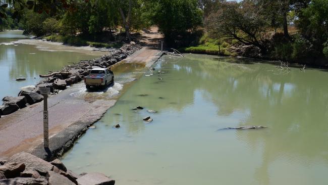 A bloke put his life at risk at Cahills Crossing on Friday August 14 when he went to grab the attention of crocodiles by slapping the water. The water level reading in the bottom left corner is where the man was crouching. Picture: Campbell Brodie