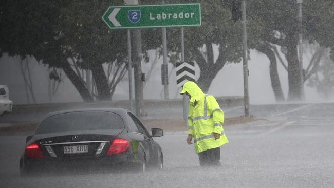 Rescue workers check on cars flooded by the sudden storms. Picture: Jason O'Brien