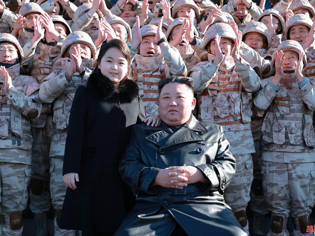 North Korea's leader Kim Jong-un and his daughter posing with soldiers who contributed to the test-firing of the new intercontinental ballistic missile (ICBM), at an unknown location in North Korea. Picture: KCNA VIA KNS / AFP.