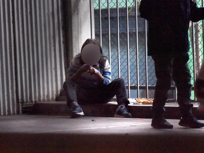 A person shoots up in the Richmond high-rise carpark. Picture: Tony Gough