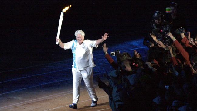 Not a perfect life, but pretty spectacular: Dawn Fraser carries the Olympic torch on its final leg towards the flame at the 2000 Sydney games. Picture: AAP/Dave Hunt