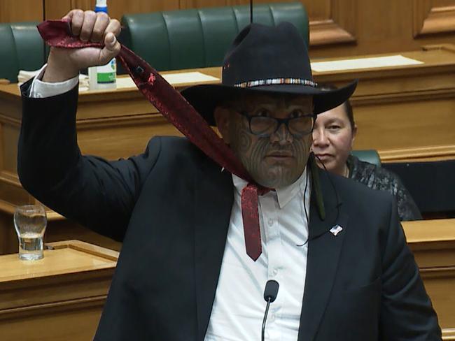 TOPSHOT - This television frame grab taken from TVNZ television on December 3, 2020 shows co-leader of New Zealand's Maori party Rawiri Waititi simulating a noose during his maiden speech in Wellington. - Waititi was ejected from parliament on February 9, 2021 for refusing to wear a necktie, wearing instead a hei-tiki, a traditional gemstone pendant, in a move he said was forcing indigenous people to wear a "colonial noose". (Photo by - / TVNZ / AFP) / RESTRICTED TO EDITORIAL USE - MANDATORY CREDIT â AFP PHOTO / TVNZâ - NO MARKETING - NO ADVERTISING CAMPAIGNS - DISTRIBUTED AS A SERVICE TO CLIENTS