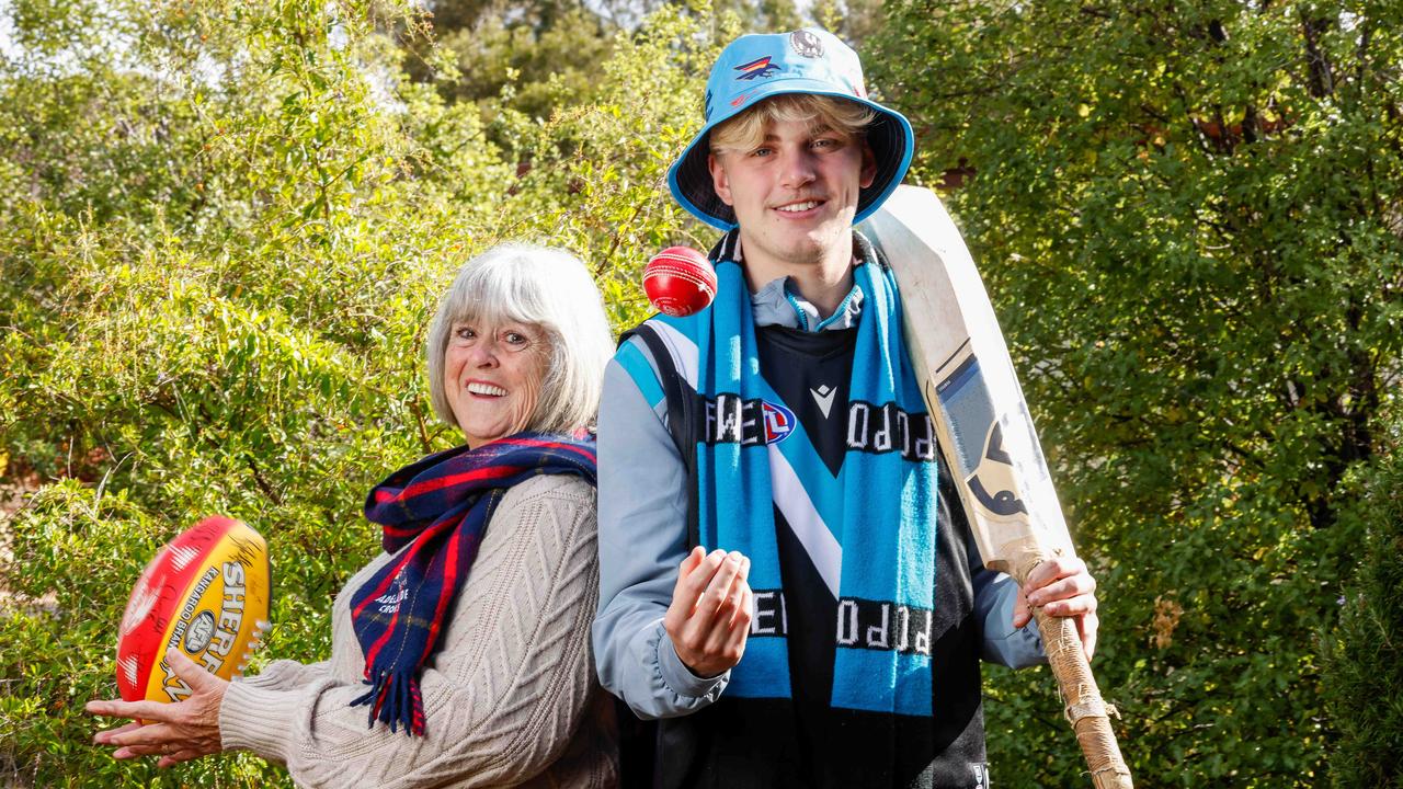 Sports fans through the generations: Grandma Pattie Miles, 75, a traditional 'one-eyed' Crows supporter and tech-savvy grandson Jack Runner, 16 … who barracks for Port and fan worships Mitch Georgiades (#19). Picture: Image/Russell Millard Photography