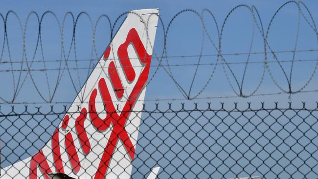 A grounded Virgin Australia aircraft parked at Brisbane Airport after the Australian government forced airline carriers to cut both their domestic and international flights in order to slow the spread of the coronavirus. (AAP Image/Darren England)