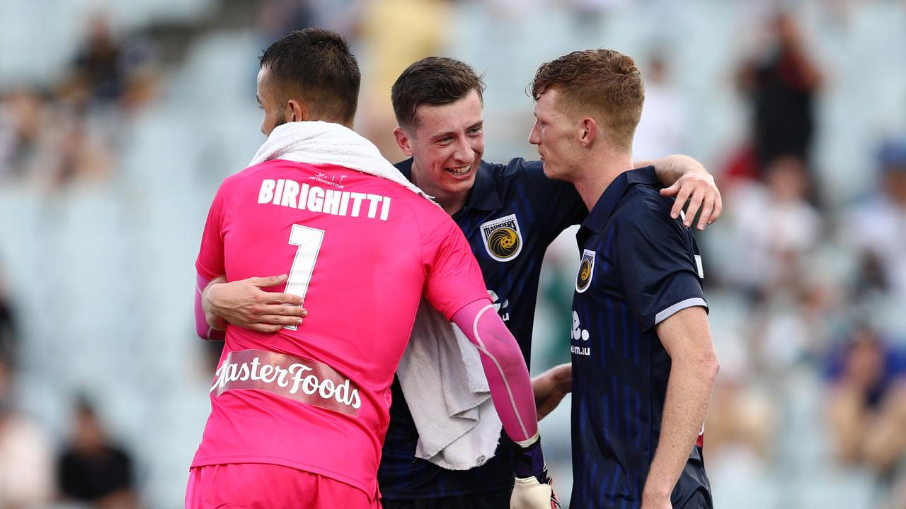 Daniel Bouman (centre) celebrates with Mariners teammates Mark Birighitti and Kye Rowles. Picture: Brendon Thorne/Getty Images