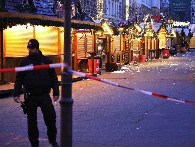 MAGDEBURG, GERMANY - DECEMBER 21: A policeman walks through the shuttered Christmas market the day after a terror attack that has left five people dead, including a small child, and over 200 injured on December 21, 2024 in Magdeburg, Germany. Police arrested a man after he drove a black BMW past security obstacles and into the busy Christmas market in the early evening yesterday. The attacker, identified as Taleb A., is reportedly a Saudi national who has been living in Germany since 2006 and worked as a psychotherapist. In social media posts he was critical of Germany but also of Islam and the "Islamization" of Germany. He expressed support for policies of the far-right Alternative for Germany (AfD). (Photo by Omer Messinger/Getty Images)