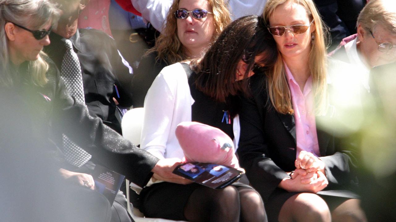 Ingrid Poulson is comforted at the funeral of her father, Peter Poulson, and her children Sebastian and Marilyn Kongsom, in 2003. Picture: Scott Hornby.