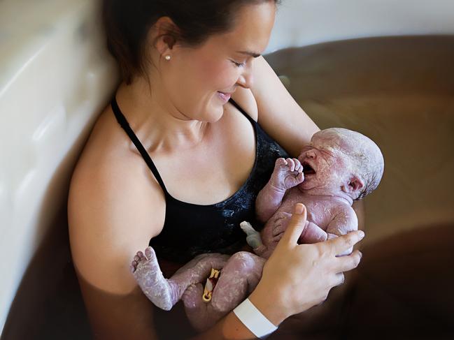 Baby love, mum Melanie Bartrim looking relieved after the water birth of baby Ashlyn, 2016. Photo: Minna Burgess Photography