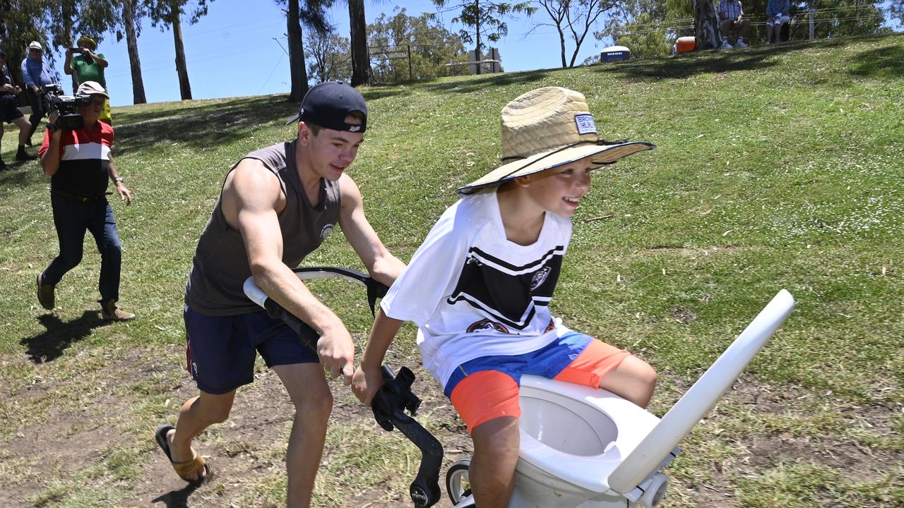 Cruz Williamson, 16, provides the muscle to propel jockey Simon Collette, 11, during the Great Australia Day Dunny Race.