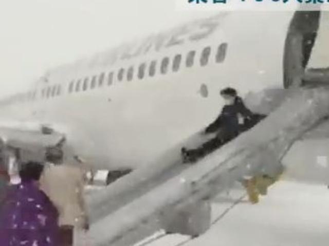 CREDIT: YouTube/DoshinWeb More than 160 passengers and crew slid down emergency chutes in swirling snow after engine smoke forced a Japan Airlines domestic flight to abort takeoff and smoke entered the cabin.