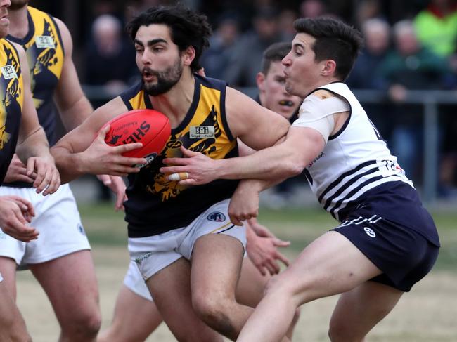 Whittlesea’s Xavier Dimasi tries to burst through a tackle against Bundoora.