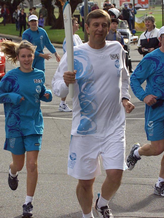 Dennis Cometti carries the Olympic torch from Fremantle to Joondalup during the 2000 Olympic Torch Relay.