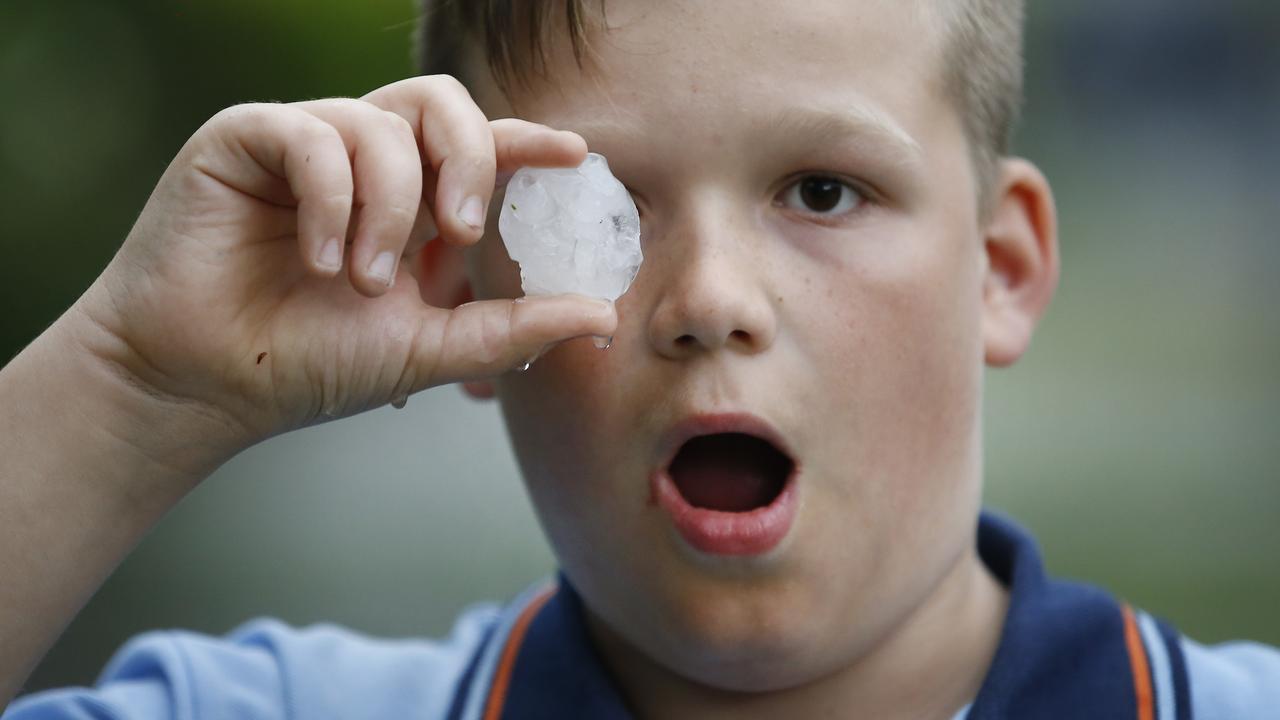 Cooper 10, holds one of the large hail stones that pelted down in Templestowe, Victoria in 2017. Picture: David Caird