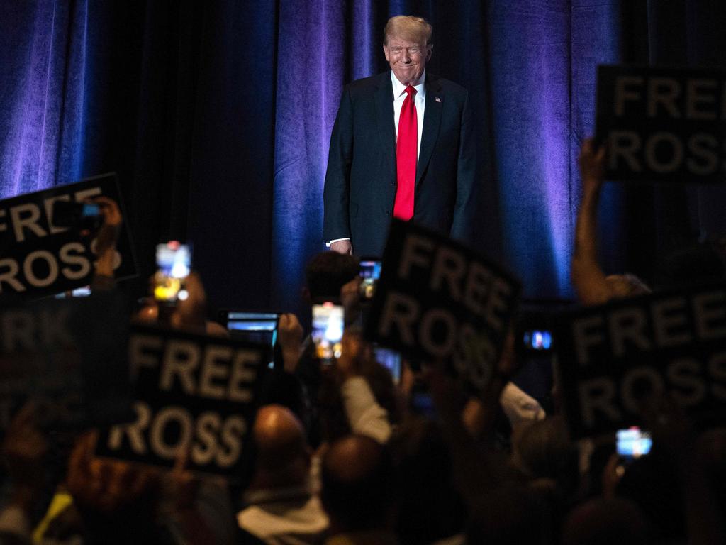 People hold up signs reading "Free Ross" as Donald Trump arrives to address the Libertarian National Convention in Washington, DC, May 25, 2024. Picture: Jim Watson/AFP