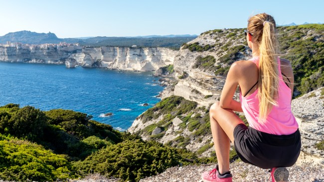 Pretty woman enjoying great vacations in Corsica and looking at Bonifacio village and cliffs.