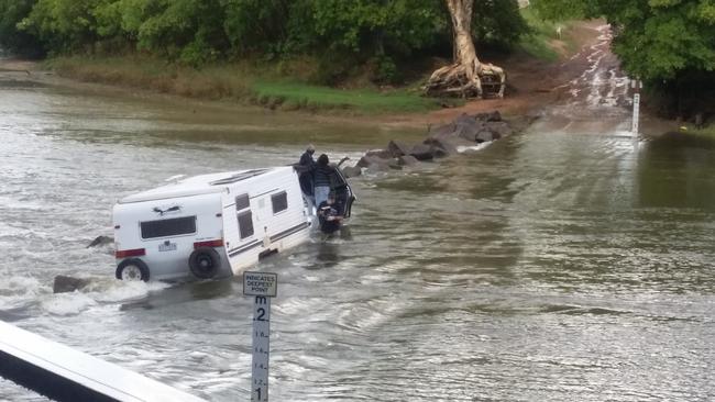 A man and three occupants manage to escape the flooded vehicle after it was washed off Cahills Crossing. PICTURE: John McNeur