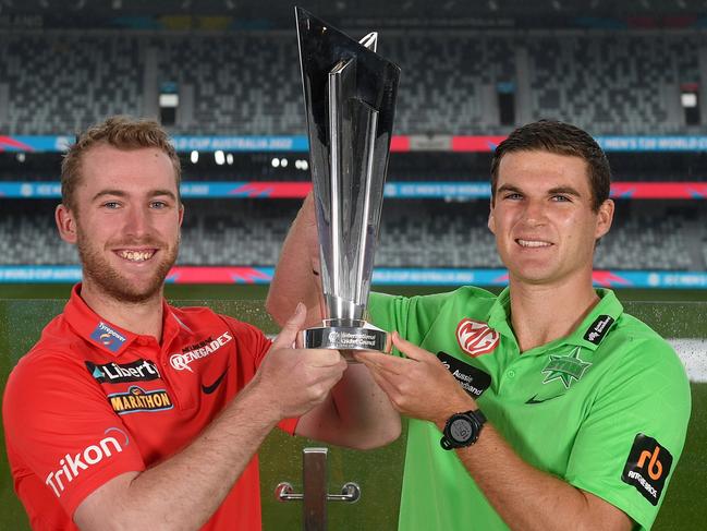 Mackenzie Harvey of the Renegades and Tom O'Connell of the Stars pose with the ICC T20 Cricket World Cup Trophy. Picture: Morgan Hancock