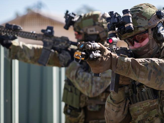 An Australian Army special operations force combat team featuring Special Operations Engineer Regiment reinforcement training cycle personnel prepares to clear a building of threats as part of a training activity at Holsworthy Barracks, Sydney. *** Local Caption *** Australian Army special operations combat engineers and other technical specialists from the Special Operations Engineer Regiment at Holsworthy Barracks, Sydney, offer unique and vital technical enablement skills to the Australian Defence Force's special operations capability.  Special Operations Engineer Regiment special operations force soldiers are highly trained to work as an integral part of an expeditionary Special Operations Task Force both within Australia and overseas.  Special Operations Engineer Regiment was established on 24 February 2012 from the Incident Response Regiment, which was previously raised in May 2002. The unit's motto is âInter Hastas et Hostesâ, which is Latin for âBetween spears and enemiesâ, signifying the traditional sapper (or combat engineer) role and the enduring unit requirement to operate in the dangerous space between enemy forces and own troops.  Special Operations Engineer Regiment reports to Headquarters Special Forces Group, a brigade-level formation within Special Operations Command.  Special Operations Commandâs mission is to prepare and employ special operations forces in order to defend Australia and its national interests.