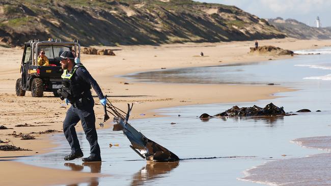 Police pull small pieces of the wreckage from the water. Picture: Alan Barber