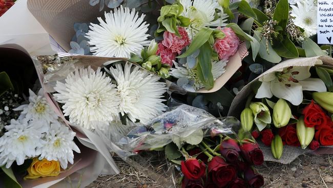 Floral tributes including one from the Cessnock Ambos left near the scene of the horrific bus crash. Picture: Jonathan Ng