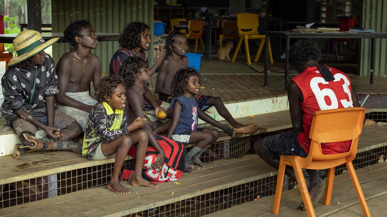 Children enjoy a story on the steps of Gamardi Homeland Learning Centre in Arnhem Land. Pictures: Rebecca Parker