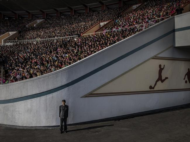 A huge crowd at the Kim Il Sung stadium awaits the start of the Pyongyang marathon. An official guards the exit. Pyongyang, North Korea. Picture: Roger Turesson Dagens Nyheter/World Press Photo