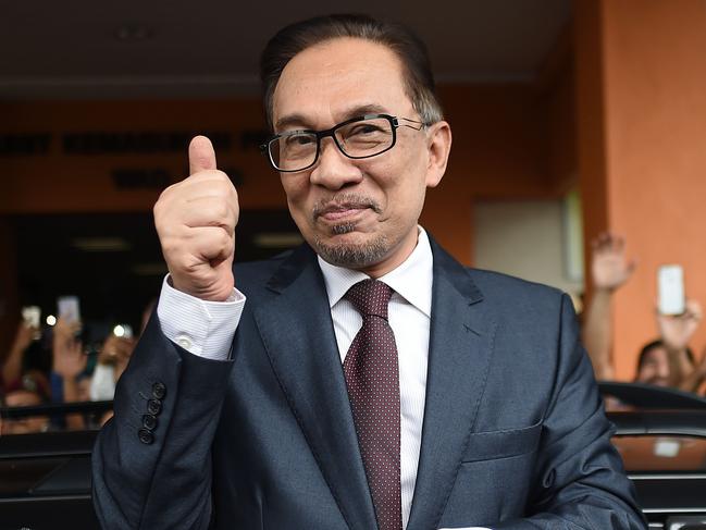 Jailed former opposition leader and current Federal opposition leader Anwar Ibrahim greets supporters after his release from the Cheras Hospital Rehabilitation in Kuala Lumpur on May 16, 2018. The release of Anwar from prison marks yet another sharp turn in a roller-coaster political life that has left a profound mark on Malaysian politics and society. Anwar was pardoned and released on on May 16, 2018 after serving three years for a sodomy conviction widely considered a railroad job and now quashed following the stunning defeat of a Malaysian regime that had ruled for six decades.  / AFP PHOTO / MOHD RASFAN