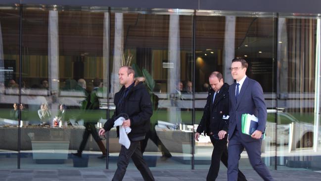 Australian Federal Police officer Joshua Rod Tiffen (far left) and his twin brother Kenan Lee Tiffen leave court with their lawyer, Tom Taylor.