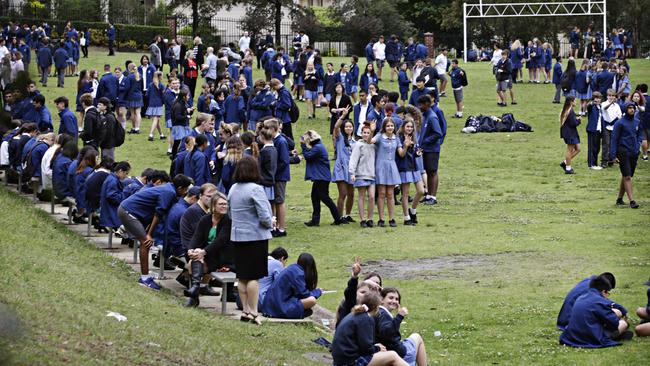 Students of the lawn of Castle Hill High School after it had to be evacuated over email threats on October 27. Picture: Adam Yip