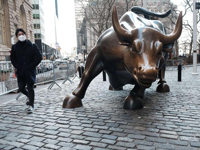 NEW YORK, NEW YORK - JANUARY 11: A man walks by the Wall Street Bull by the New York Stock Exchange (NYSE) on January 11, 2022 in New York City. After yesterdays sell off, the Dow was down only slightly in morning trading.   Spencer Platt/Getty Images/AFP == FOR NEWSPAPERS, INTERNET, TELCOS & TELEVISION USE ONLY ==