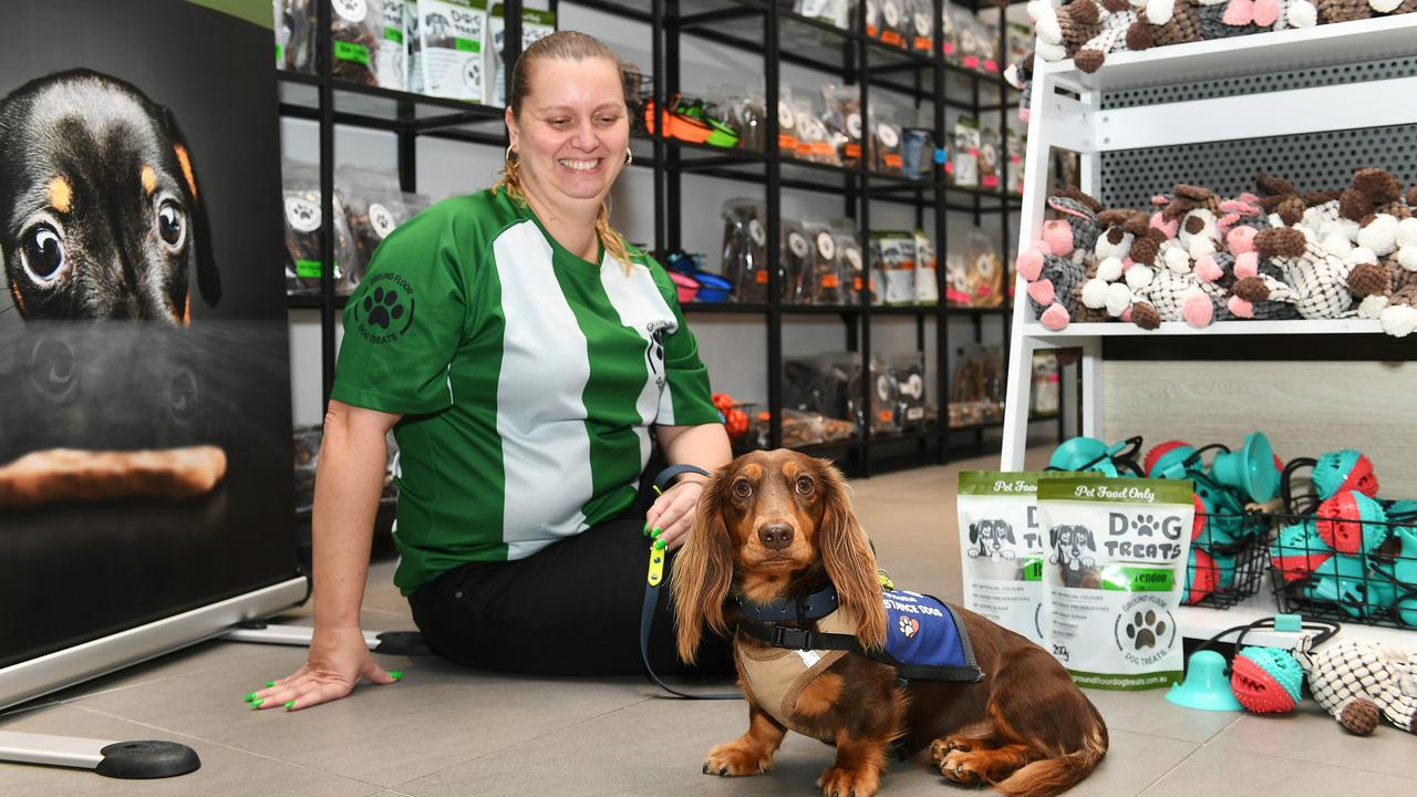 Ground Floor Dog Treats co-owner Linda Welsh sits with her husband Paul's Assistance dog, Milo. The couple have opened a temporary store at Townsville Shopping Centre. Picture: Shae Beplate.