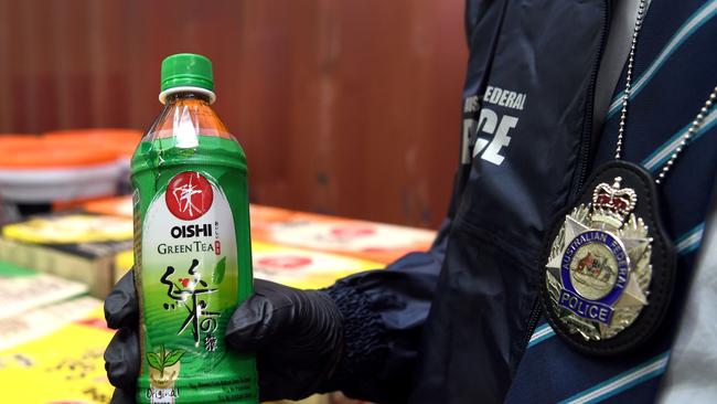 An Australian Federal Police officer holds a bottle of the ‘green tea’.