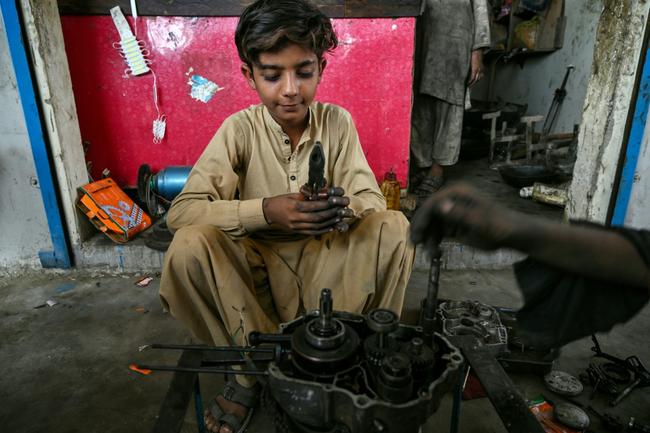 Kamran Imran, 10, works at a motorcycle repair shop where he earns about 90 cents a day