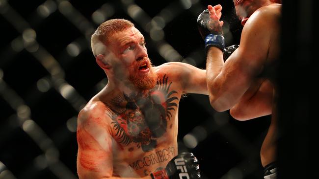 Conor McGregor (L) punches Nate Diaz during UFC 196.